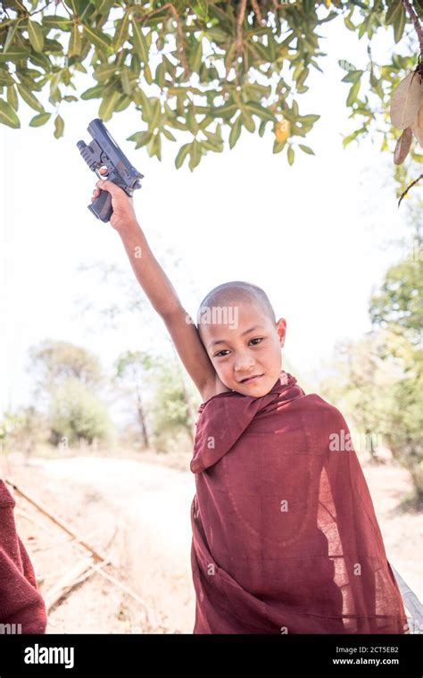 Novice Monk with a toy gun at a Buddhist Monastery between Inle Lake and Kalaw, a popular 2 day ...