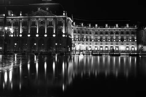 Premium Photo | Reflection of buildings in lake at night