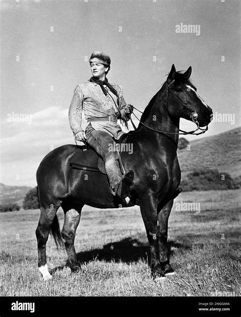 John Wayne on horse, publicity photo 1940s, western outfit Stock Photo ...