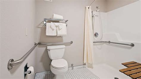 Toilet, shower seat, grab bars, and towel rack