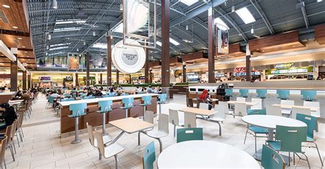 the inside of a restaurant with tables and chairs, people sitting at ...