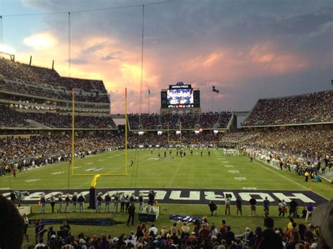 a football stadium filled with lots of people watching the sun go down in the sky