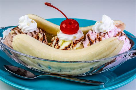 a banana split with ice cream, whip cream and a cherry on top in a bowl