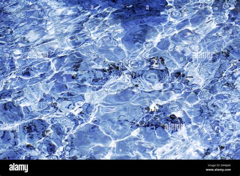 The sun reflects on the surface of a fountain filled with crystal clear ...