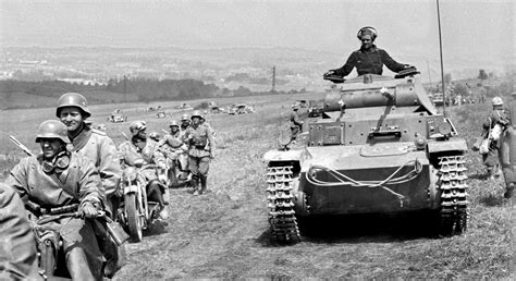 1940, France, Un Pz.Kpfw. II et des motards allemands montent au front et croisent des POWs ...