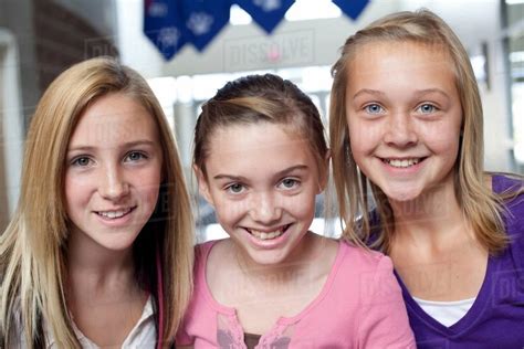 Close up portrait of three teen and pre-adolescent girls smiling ...