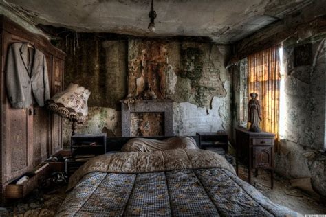 an old bedroom with a bed and fireplace in the corner, next to a window