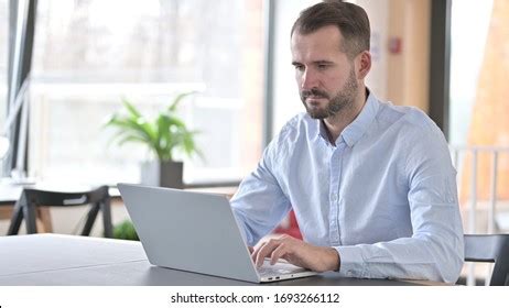 Serious Young Man Working On Laptop Stock Photo 1693266112 | Shutterstock