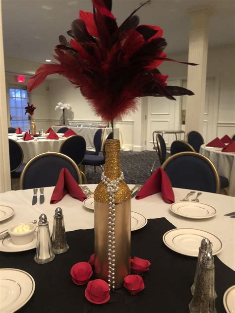 there is a vase with feathers on it at the center of this dining room table