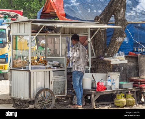 Jakarta, Indonesia - February 20, 2018: Street seller selling Indonesian food on the busy street ...