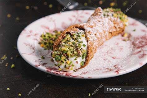 Homemade Sicilian Cannoli with ricotta filling garnished with pistachios and sugar powder ...