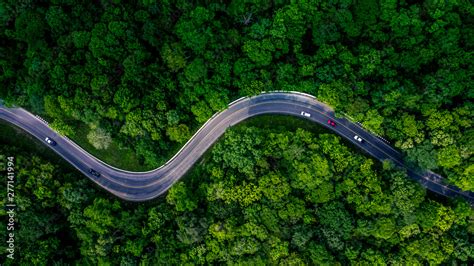 Forest Road view from above, Aerial view asphalt road in tropical tree forest with a road going ...