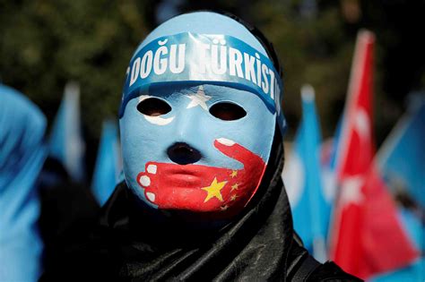 File Photo: Ethnic Uighur demonstrator wears a mask as she attends a protest against China in ...