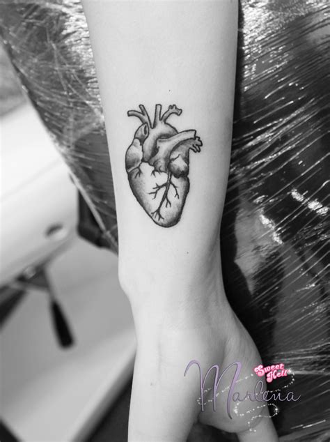 Minimal black human heart tattoo on a wrist. Black line styled ...