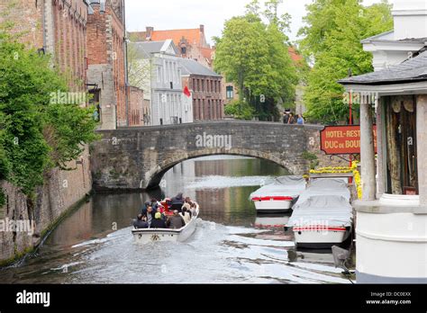 Bruges Belgium canal tour boat and stone bridges Stock Photo - Alamy