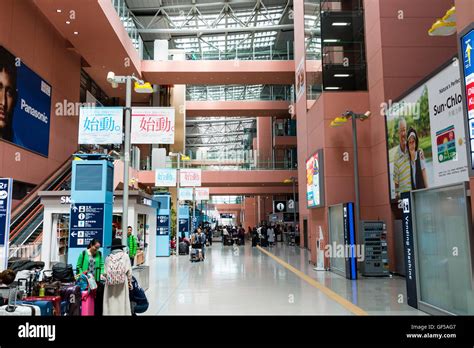 Kansai airport, Japan. Interior, terminal 1. General view along inside with people, interior ...