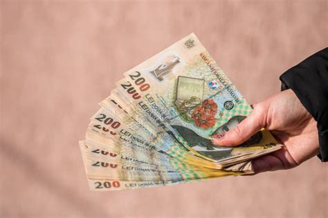 Shallow Focus Shot of a Hand with 200 Romanian Leu Banknotes on a Pinky ...