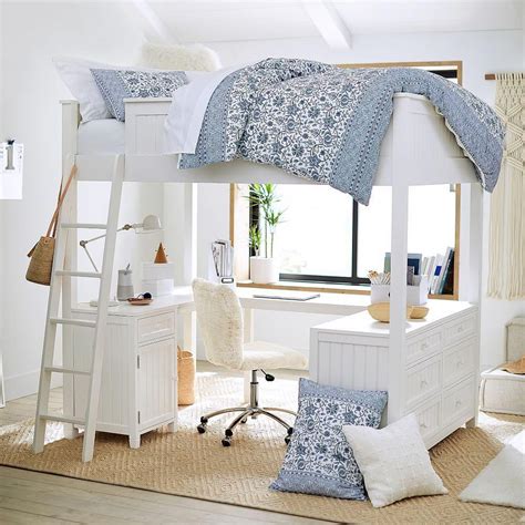 a white bunk bed sitting in a bedroom next to a desk and chair with pillows on it