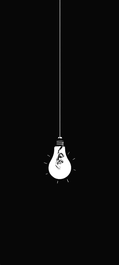 a black and white photo of a light bulb hanging from a wire with a hand on it