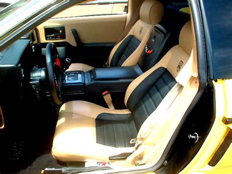 the interior of a yellow sports car with black leather and tan trim ...