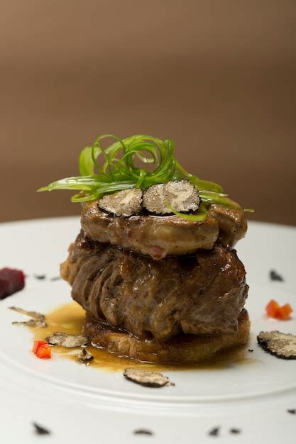 Premium Photo | Sliced truffles topped on a grilled steak, beef and pork, with vegetable and sauce