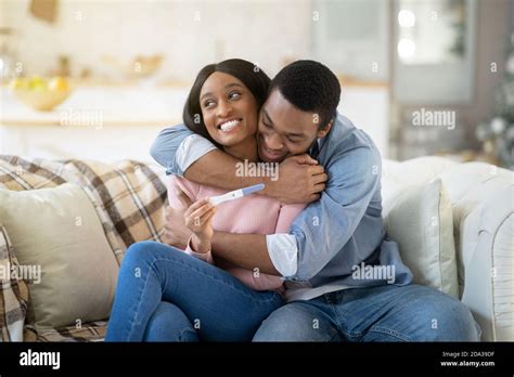 Loving black husband hugging his wife with positive pregnancy test at ...