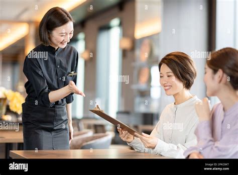 Restaurant staff showing the menu Stock Photo - Alamy