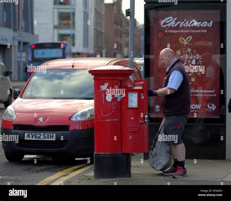 Royal Mail postman collecting letters street red postbox van talking to ...