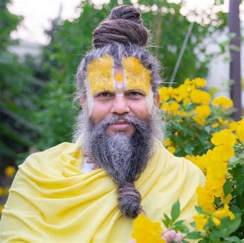 a man with yellow paint on his face and beard standing in front of some ...