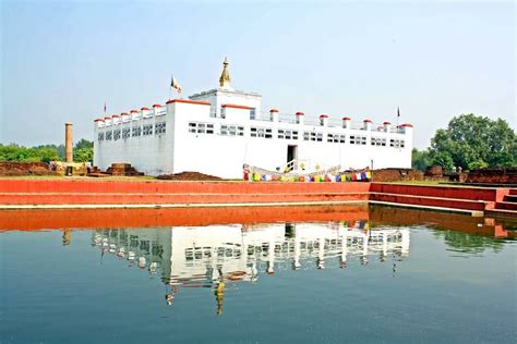 a large white building sitting next to a body of water