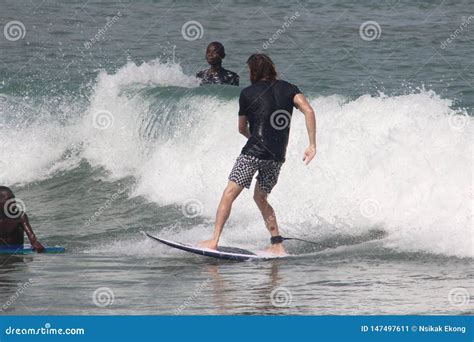 A Tourist is Enjoy Surfing in Lagos Beach while Two Admirers Watch ...