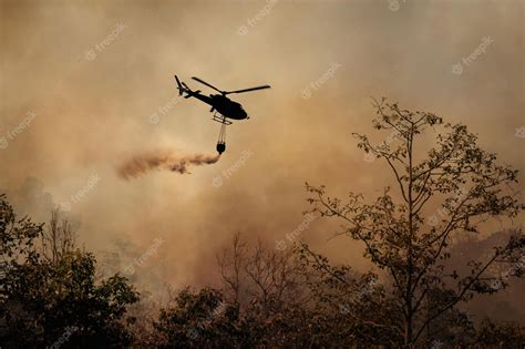 Premium Photo | Fire fighting helicopter dropping water onto wildfire