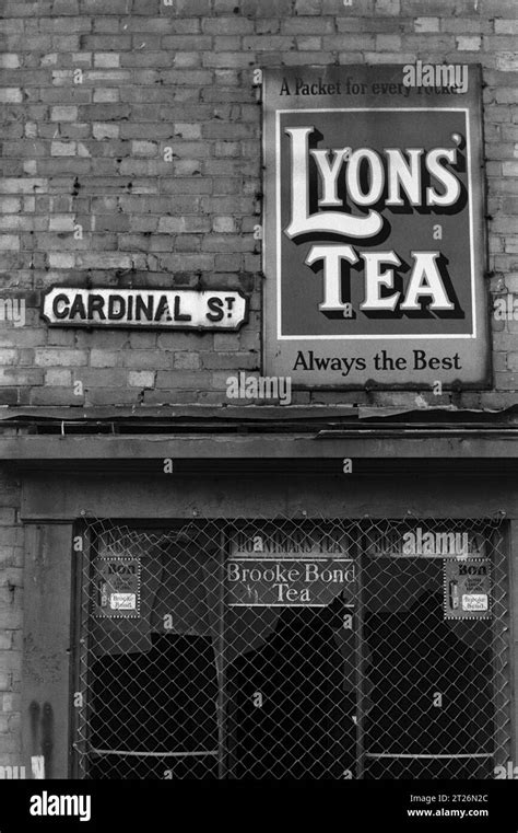 Corner shop on Cardinal Street with a broken glass window, displaying adverts for Brook Bond Tea ...