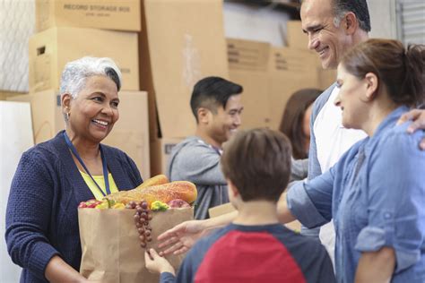 Multi-ethnic group of volunteers work at food bank. | Corn Refiners ...