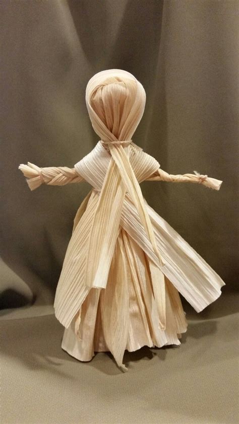 an origami doll is standing on one leg and arms are wrapped around the other