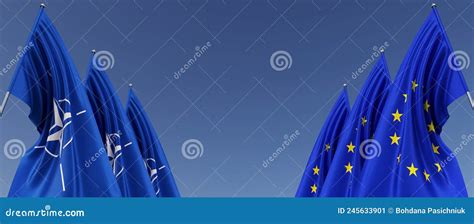 Three EU and NATO Flags on Flagpoles on Sides. Flags on a Blue ...