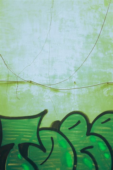 A green wall with some graffiti on it photo – Free Graffiti Image on ...