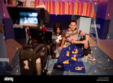 The bedtime hour on CBeebies presented by regulars Chris Jarvis and Pui Fan Lee Stock Photo - Alamy