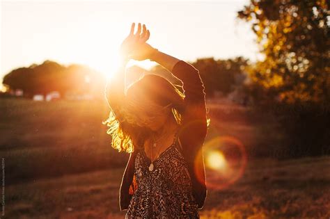 "A Young African American Woman Dancing In A Field While The Sun Is ...