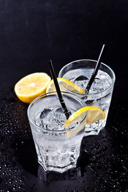 Dos vasos de agua carbonatada fría con cubitos de hielo y rodajas de limón | Foto Premium