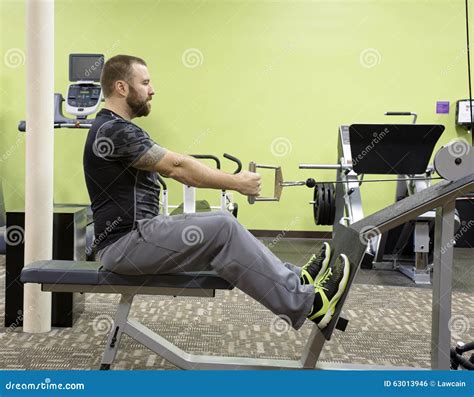 Man Using Seated Row Machine Stock Photo - Image of fitness, black ...