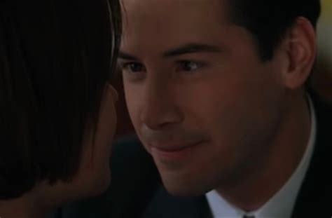 a man in a suit and tie is looking at the woman's face with her eyes closed