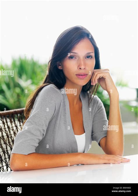 Beautiful woman sitting at patio table Stock Photo - Alamy