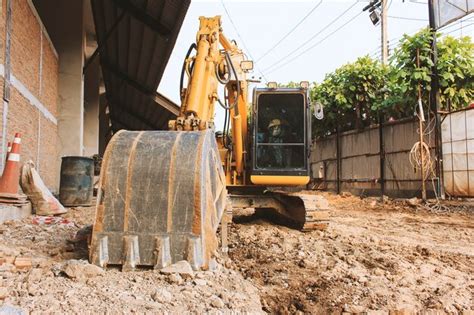 Premium Photo | Excavator loader or backhoe at a construction site with soft-focus in the ...