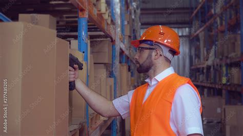 Fotografia do Stock: manager using wireless barcode scanner scanning labels on boxes before ...