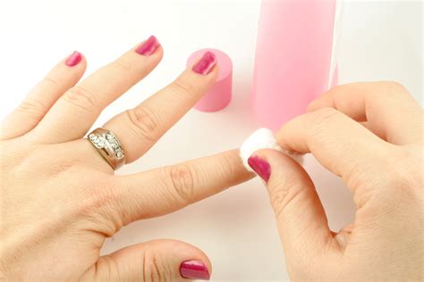 woman holds cotton ball with nail polish remover