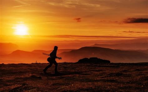 Premium Photo | Happy man standing on a cliff at sunset