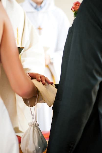 Premium Photo | Wedding couple receiving blessing from priest