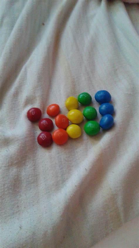 there are many different colored candies on the bed