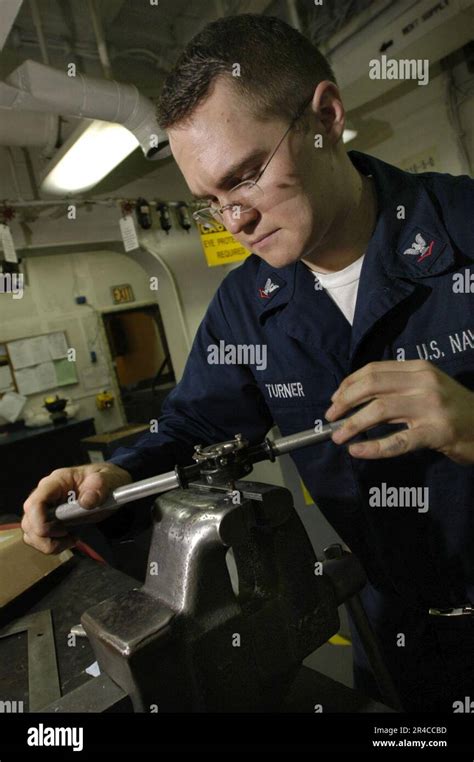 US Navy Aviation Structural Mechanic 3rd Class fabricates new threads for a bolt using a tap-and ...